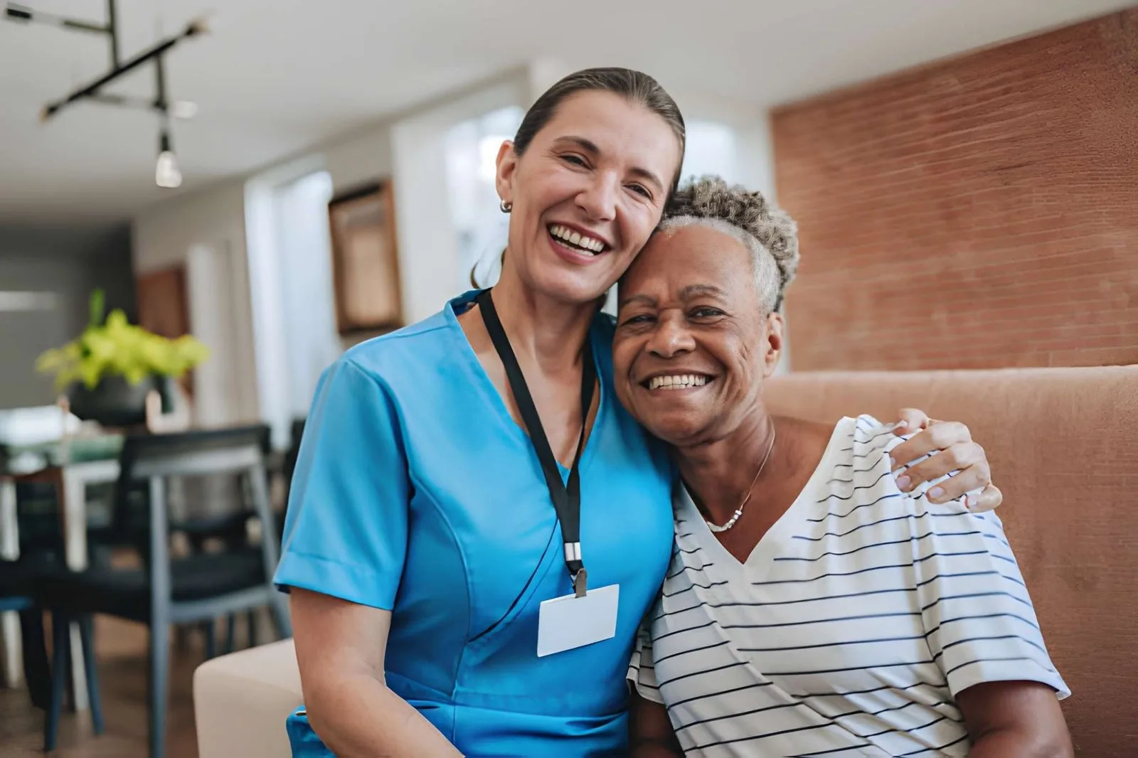 Care professional sharing a warm moment with an older adult
